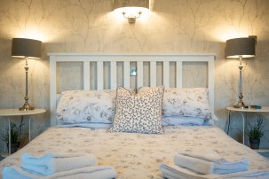 a bed illuminated by wall lights